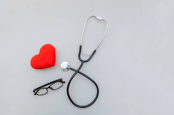 Apparecchiatura medica stetoscopio o occhiali fonendoscopio e cuore rosso isolato su sfondo bianco. Dispositivo strumentale per medico. Concetto di assicurazione sulla vita sanitaria
 - Foto, immagini