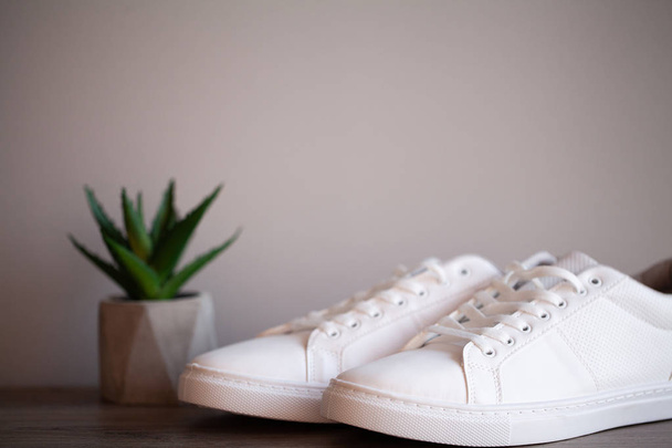 Pair of new stylish white sneakers on floor at home - Zdjęcie, obraz