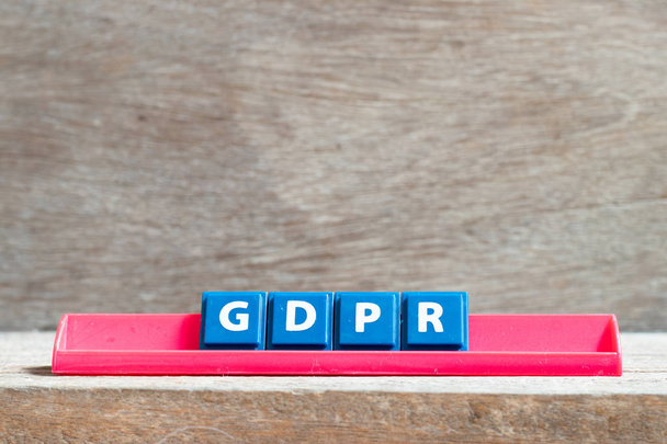 Lettre carrelée sur support rouge en mot RGPD (Règlement général sur la protection des données) sur fond bois
 - Photo, image
