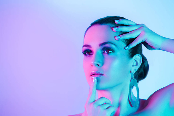 Portrait of model posing in studio with color neon lights - 写真・画像