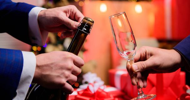 Last minute before new year. New year countdown. Hands opening champagne bottle and hold glass christmas decorations background. Drink champagne or sparkling wine. Celebrate new year with champagne - Photo, Image