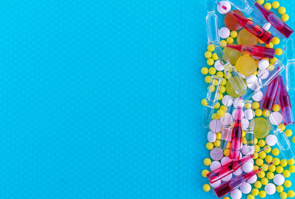 Ampolle per iniezione, pillole e vitamine su sfondo blu. Concetto medico
. - Foto, immagini