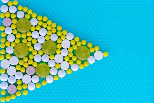 Pills and vitamins in the form of a triangle on a blue background. Medical concept. - Valokuva, kuva