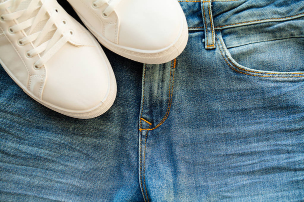 Jeans e tênis brancos na prateleira da loja
 - Foto, Imagem