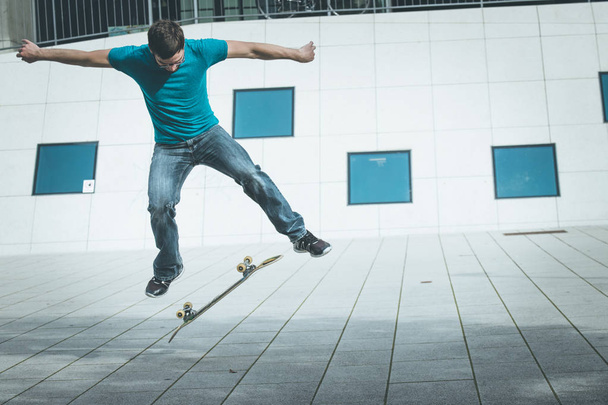 male skateboarder doing jump trick - Foto, afbeelding