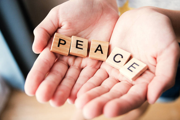 the word Peace is written in cubic letters in hands, selective focus - Fotoğraf, Görsel