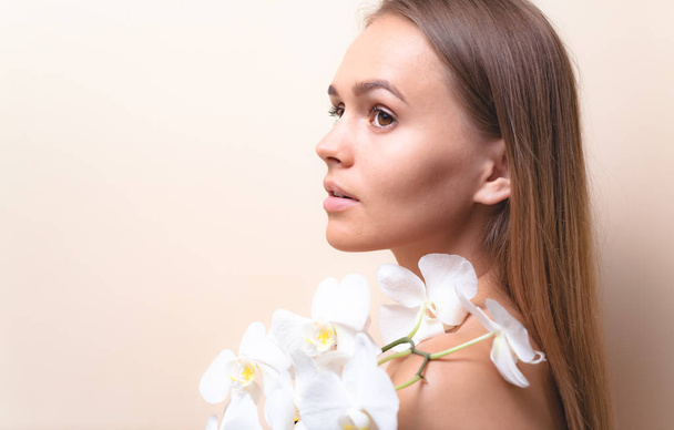 Portrait rapproché d'un beau modèle avec des fleurs d'orchidée blanche
. - Photo, image