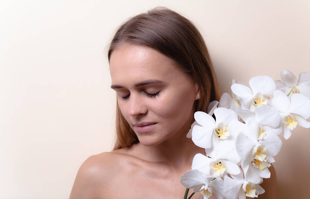 Closeup portré egy gyönyörű modell, fehér orchidea virágok. - Fotó, kép