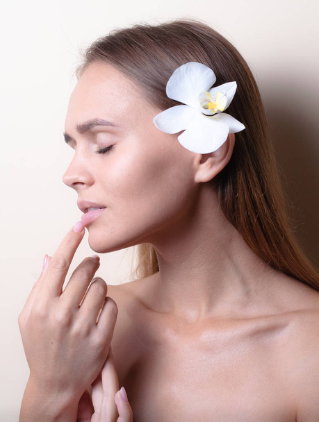 Retrato de primer plano de un hermoso modelo con flores de orquídea blanca
. - Foto, Imagen