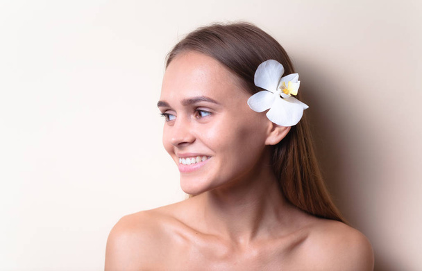 Zbliżenie portret pięknego modelu z białym orchidei kwiatów. - Zdjęcie, obraz