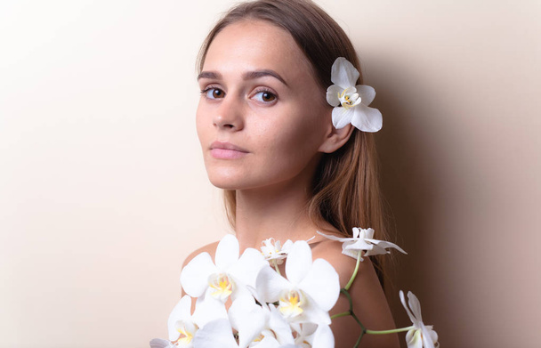 Retrato de close-up de um belo modelo com flores brancas de orquídeas
. - Foto, Imagem