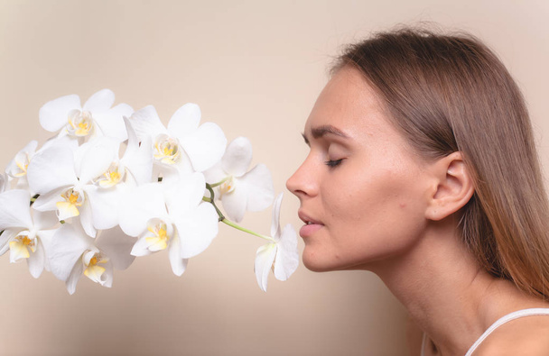 白蘭の花を持つ美しいモデルのクローズアップ肖像画. - 写真・画像