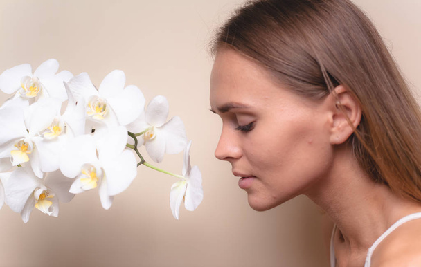 Крупним планом портрет красивої моделі з білими орхідеями
. - Фото, зображення