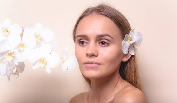 Retrato de close-up de um belo modelo com flores brancas de orquídeas
. - Foto, Imagem