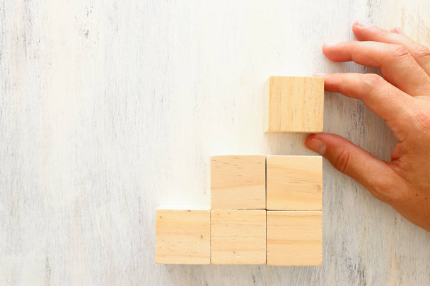 business concept of man hand arranging wooden blocks. mock up or template - Foto, afbeelding