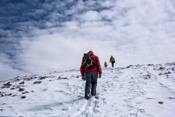Regione di Irkutsk, Russia, Slyudyanka - 13 aprile 2019: gruppo di persone sta facendo escursioni in montagna e neve tra gli abeti
 - Foto, immagini
