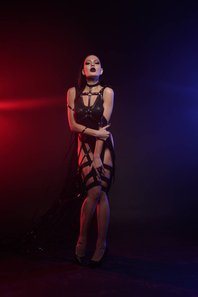hermosa mezcla de raza esbelta bailarina muscular posando en un traje de baño negro con arnés de cuero con cintas de vídeo
 - Foto, imagen