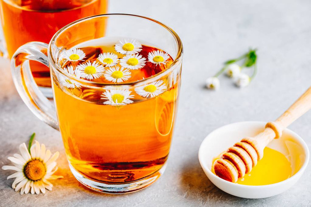 Υγιεινό τσάι βοτάνων με φρέσκα λουλούδια χαμομηλιού σε γυάλινο Κύπελλο  - Φωτογραφία, εικόνα
