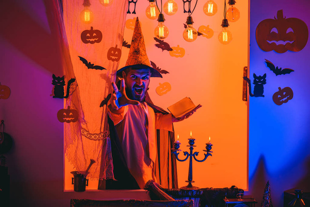 Funny wise wizard on a Halloween background. Wizard, sorcerer, warlock. Mystery and horror concept. Jack o lantern. - Zdjęcie, obraz