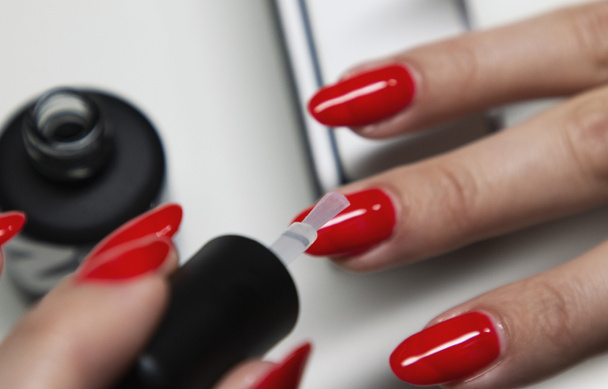 aplicação de verniz de unhas de gel vermelho nas unhas das mulheres
 - Foto, Imagem