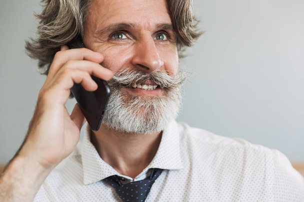 Image closeup of handsome adult man talking on cellphone while s - Foto, immagini