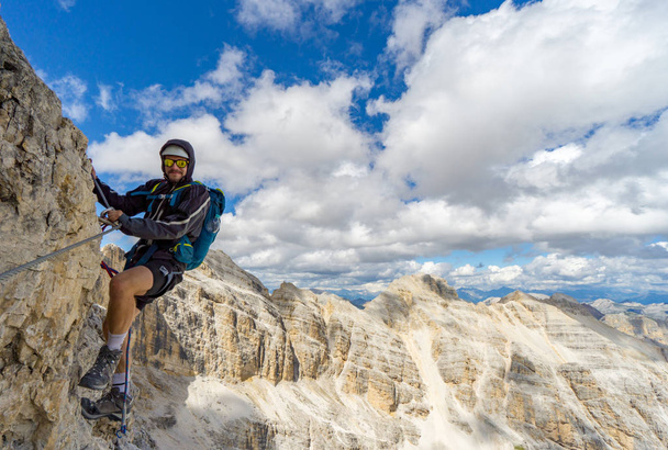 молодий чоловічий гірський альпініст на крутому і відкритому скелястому лиці кліпу
 - Фото, зображення