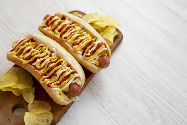 Homemade colombian hotdogs with pineapple sauce, chips, yellow m - Photo, Image