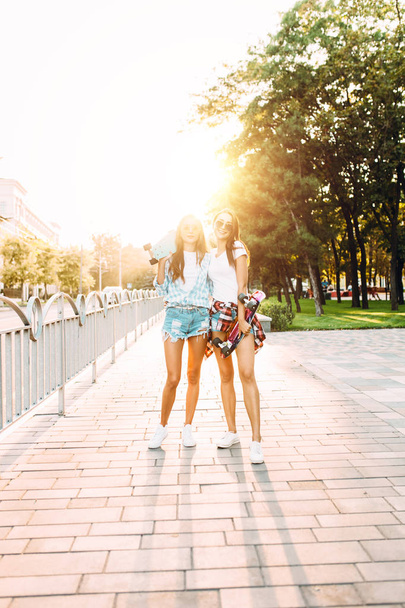 Two cheerful young girls in shorts , friends pose standing with  - Photo, Image