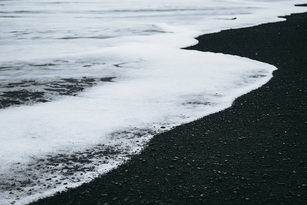 Minimalistický pohled na bílou oceánskou vodu a černý písek na Islandu - Fotografie, Obrázek