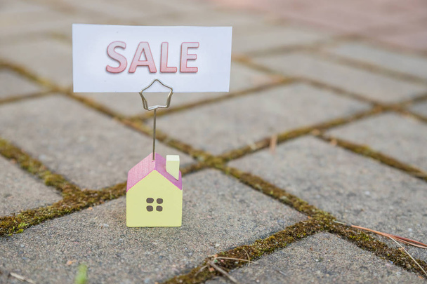 Sale sign with small model house - real estate buying concept.Copy space. home and life concept. Small model home with sunlight abstract background. house model on sale - Photo, Image