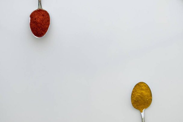 Diverses épices colorées disposées sur des cuillères
  - Photo, image