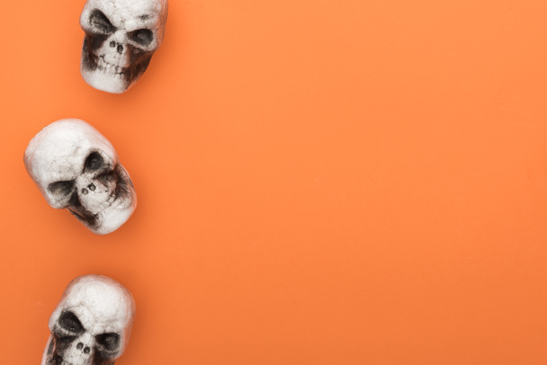 top view of decorative skulls on orange background with copy space - Фото, изображение