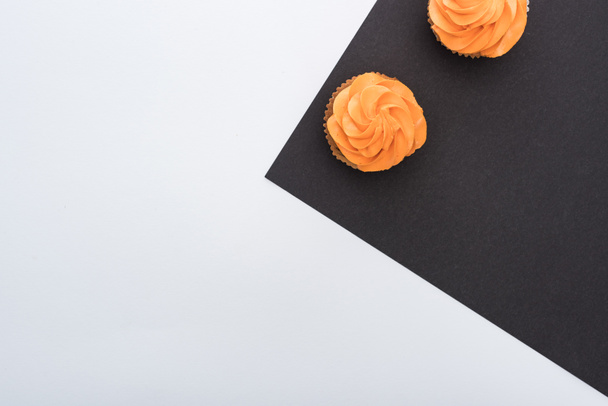 vista superior de deliciosos cupcakes de Halloween em fundo preto e branco com espaço de cópia
 - Foto, Imagem