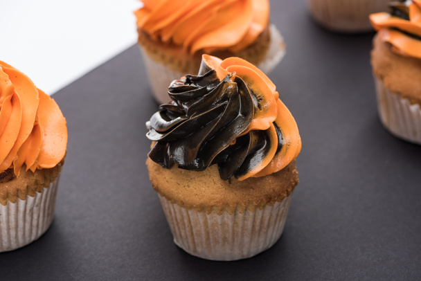 delicious Halloween cupcakes with black and orange cream - Фото, зображення