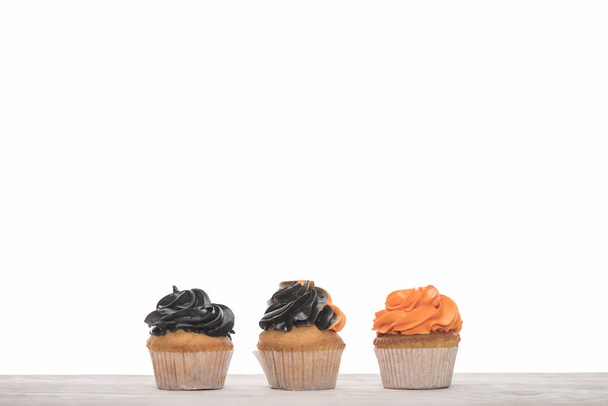 delicious Halloween orange and black cupcakes isolated on white - 写真・画像