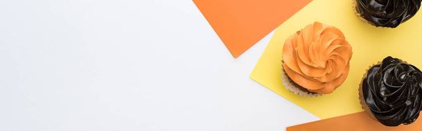 вид зверху смачні кекси на Хеллоуїн на жовтому, помаранчевому та білому тлі з місцем для тексту, панорамний знімок
 - Фото, зображення