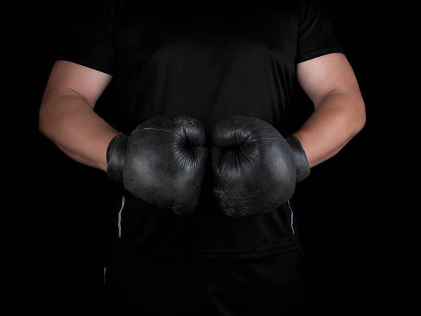 чоловік стоїть у боксерській стійці, одягнений у дуже старий старовинний чорний бокси
 - Фото, зображення