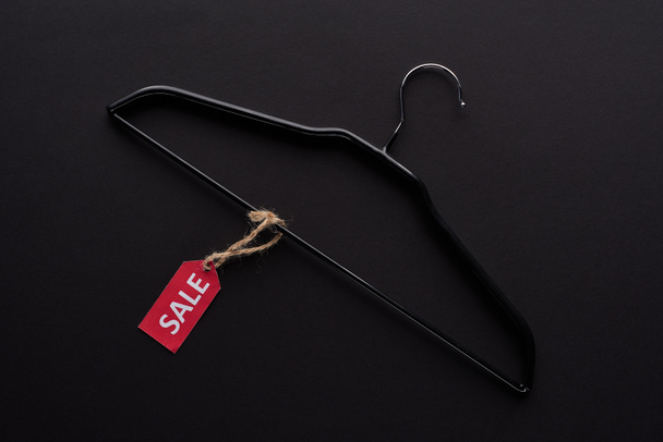 top view of hanger with sale label on black background - Zdjęcie, obraz