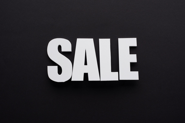 top view of white sale lettering on black background - Fotografie, Obrázek