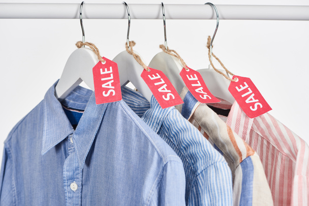 elegant shirts hanging with sale labels isolated on white - Photo, Image