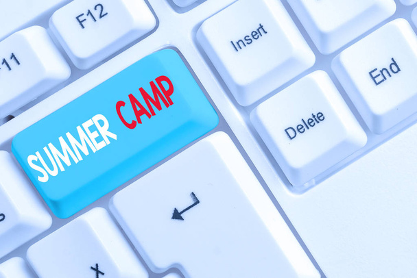 Handwriting text writing Summer Camp. Concept meaning Supervised program for kids and teenagers during summertime. White pc keyboard with empty note paper above white background key copy space. - Photo, Image