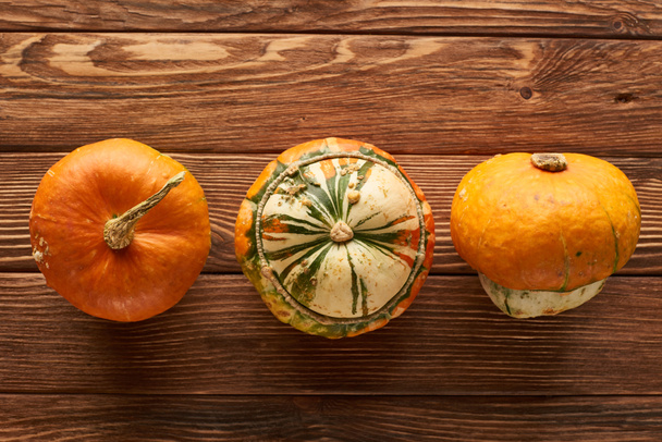 top view of various fresh pumpkins on wooden surface with copy space - Zdjęcie, obraz