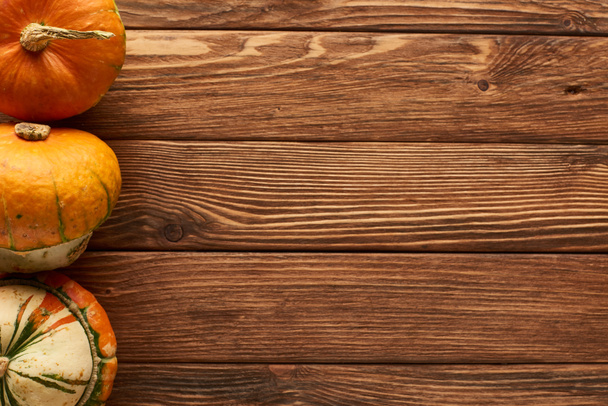 top view of uncooked pumpkins on wooden surface with copy space - Photo, Image