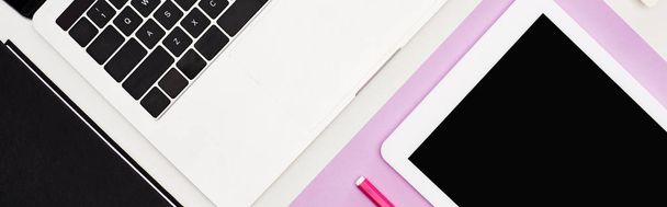 deitado plano com laptop, tablet digital com tela em branco sobre fundo violeta e branco, tiro panorâmico
 - Foto, Imagem