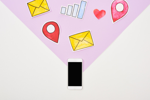vista superior del smartphone con pantalla en blanco e iconos de red social recortados en papel sobre fondo violeta y blanco
 - Foto, Imagen
