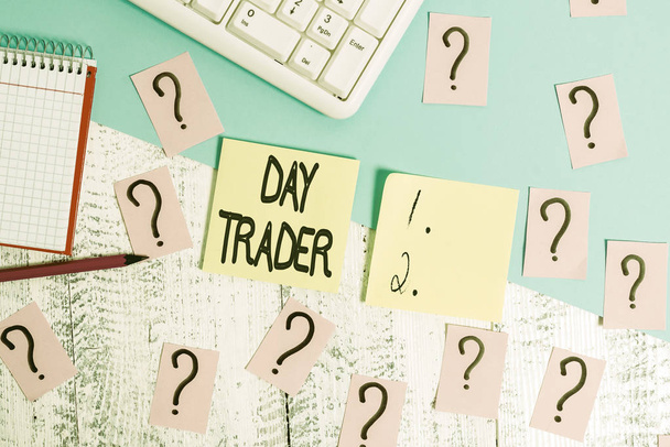 Conceptual hand writing showing Day Trader. Business photo text A demonstrating that buy and sell financial instrument within the day Writing tools and scribbled paper on top of the wooden table. - Fotó, kép