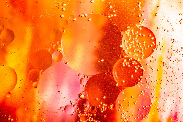 Macro shot of water oil emulsion over colored background - Фото, изображение