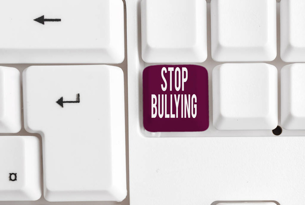 Writing note showing Stop Bullying. Business photo showcasing Fight and Eliminate this Aggressive Unacceptable Behavior White pc keyboard with note paper above the white background. - Photo, Image