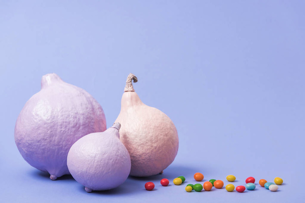 calabazas pintadas festivas con caramelos sobre fondo violeta
 - Foto, imagen