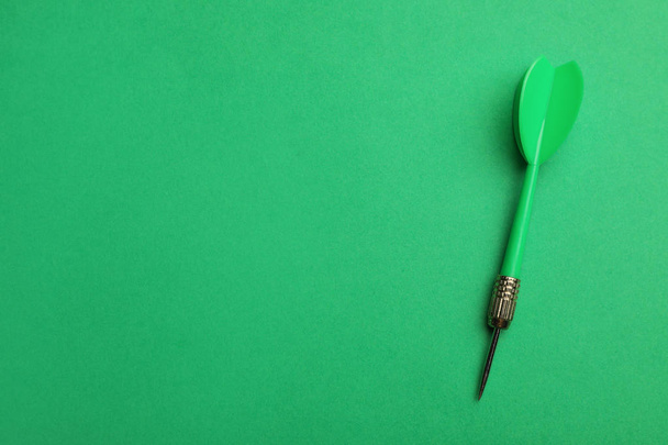 Plastic dart arrow on green background, top view with space for text - Φωτογραφία, εικόνα